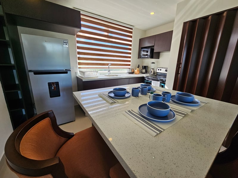 Comedor luminoso de un condominio con vista a las montañas y al mar