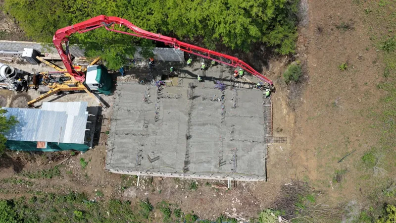 Vista aérea del colado de la losa de fundación con un camión bomba de concreto en Serena