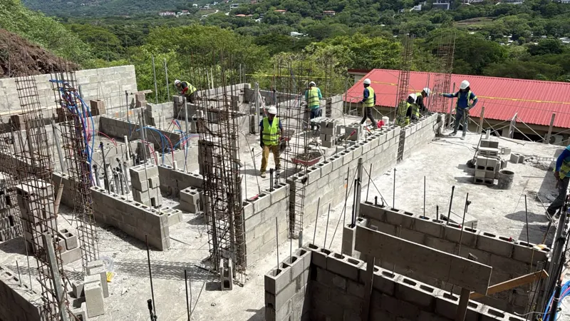 Vista cercana de paredes de bloque de concreto y columnas de varilla de acero en la obra de Serena